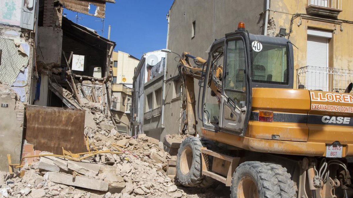 Imagen de una excavadora ayer por la mañana retirando escombros.