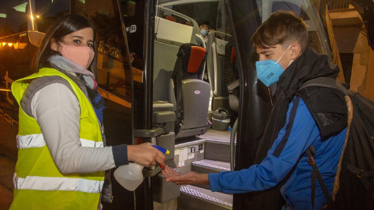 Els alumnes es posen gel hidroalcohòlic abans de pujar a l’autocar.