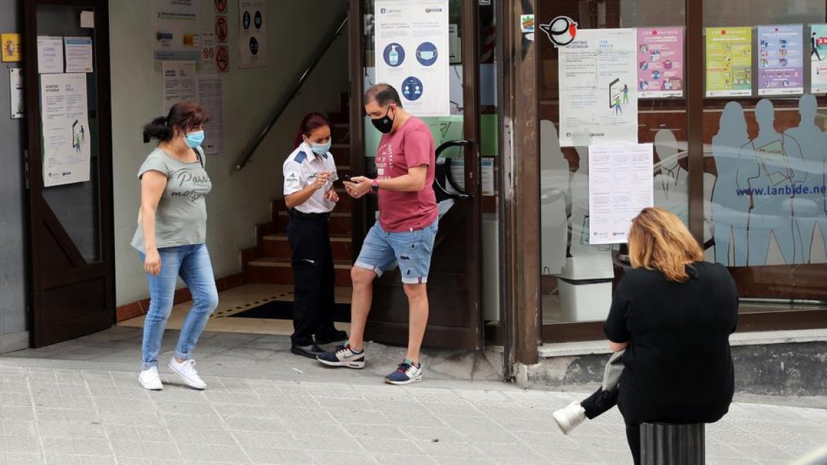 Diverses persVarias persones fan cua|cola en una oficina d'empleo.onas fan cua|cola en una oficina d'ocupació.