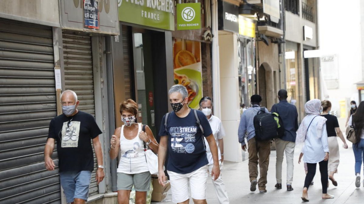 El uso de mascarilla ya es obligatorio, aunque haya distancia social. En la imagen, transeúntes ayer en el Eix Comercial de Lleida.  