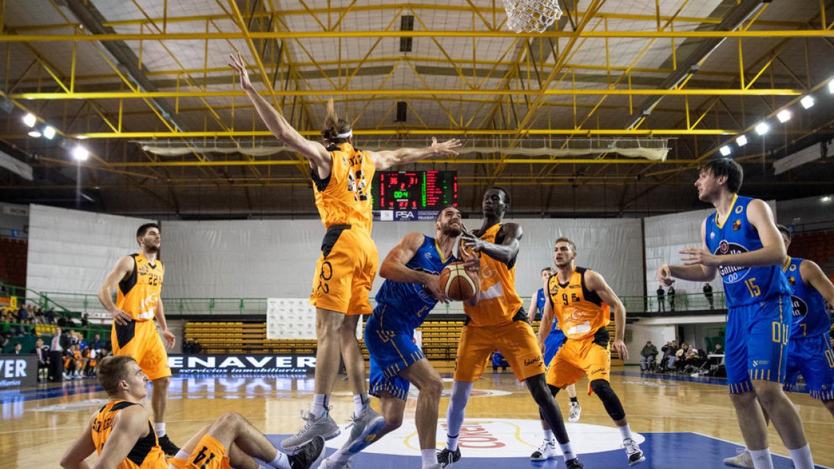 Un jugador de l’Ourense intenta recuperar una pilota davant la pressió d’Eric Stutz i Diene, que ahir va reaparèixer després de diversos partits sense jugar.