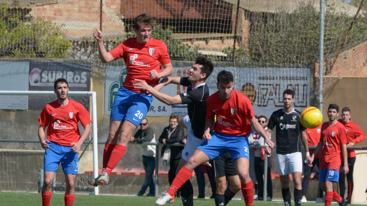 Un jugador del Juneda es estrechamente marcado por un rival durante un lance del partido.