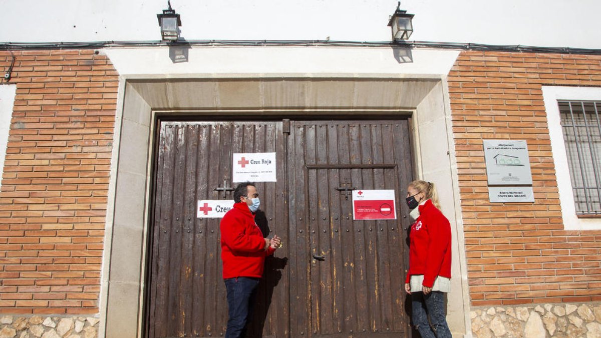 Dos treballadors de Creu Roja, a l’entrada de l’alberg.