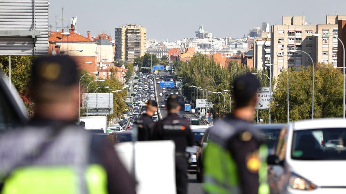 Agents de la Policia Nacional realitzen un control a la carretera A-5, a Madrid, per fer complir les restriccions de l’estat d’alarma.