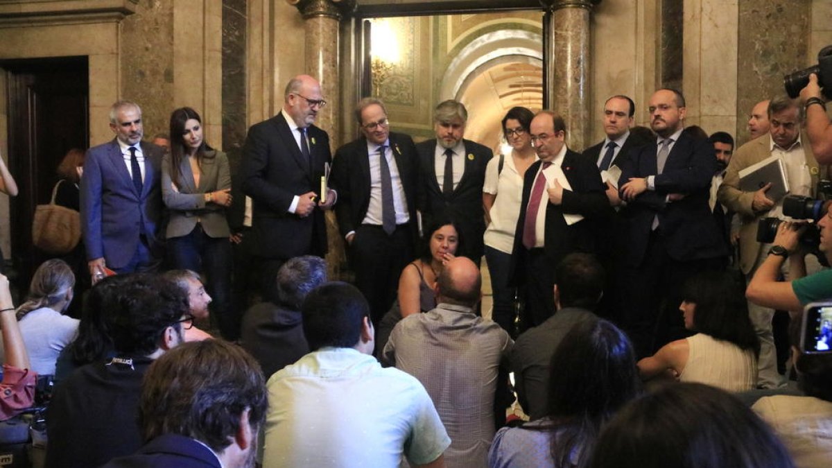 El president Torra y dirigentes de varios partidos asisten a la protesta de los periodistas en los pasillos del Parlament, ayer.