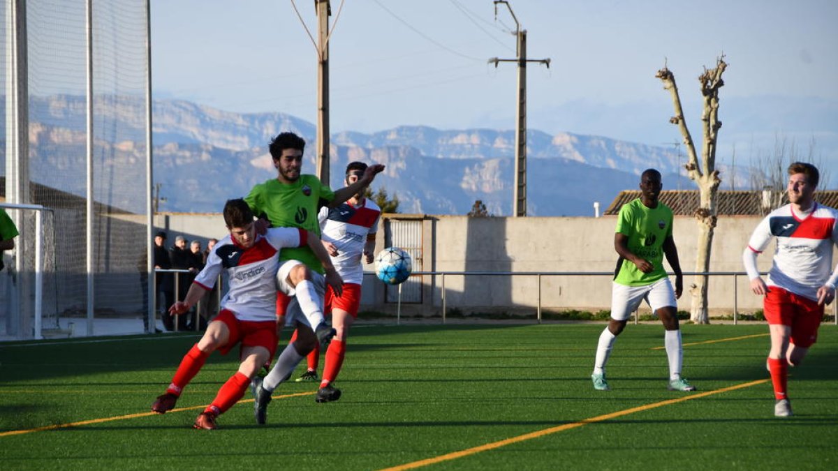 Un jugador de l’Alpicat colpeja la pilota davant la pressió d’un rival.