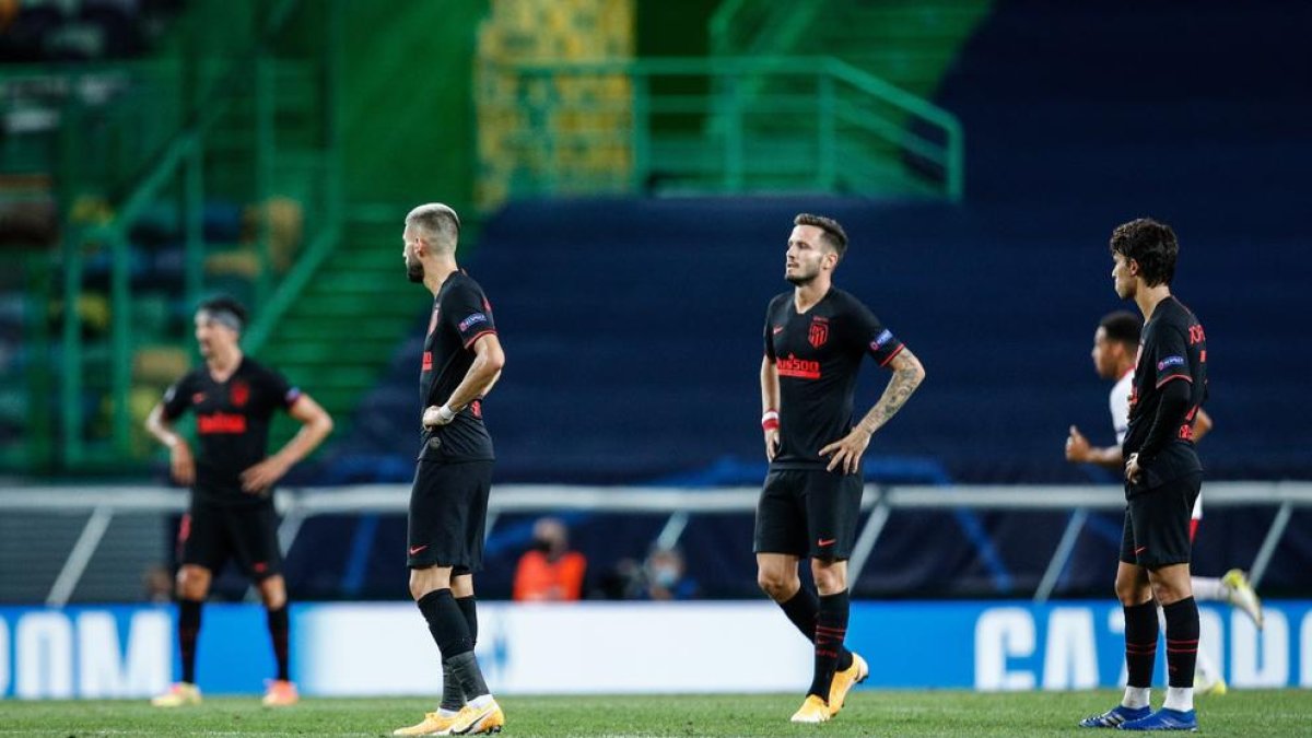 Jugadores del Atlético, que ayer vistió de azul, muestran su decepción por la derrota.