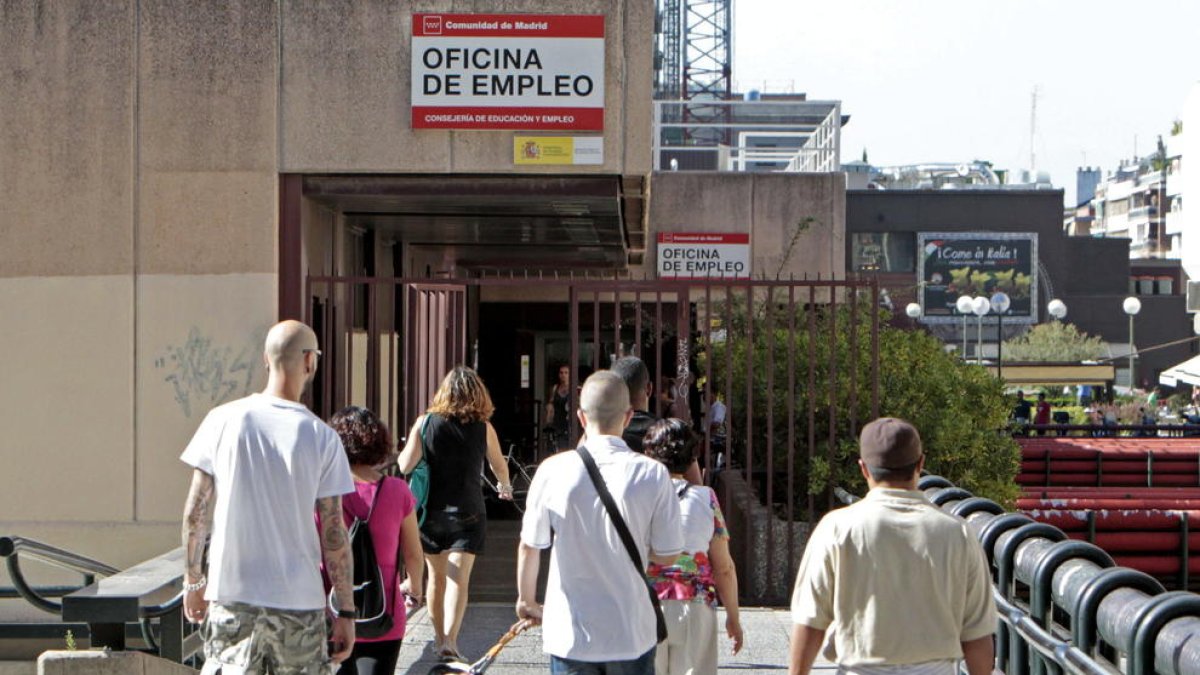 Persones caminant cap a una oficina d’ocupació a Madrid.
