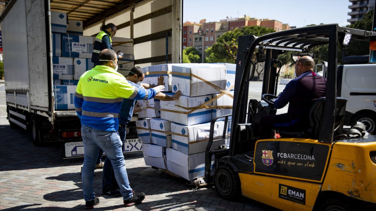 Els operaris descarreguen el material sanitari que ahir va rebre el club blaugrana.