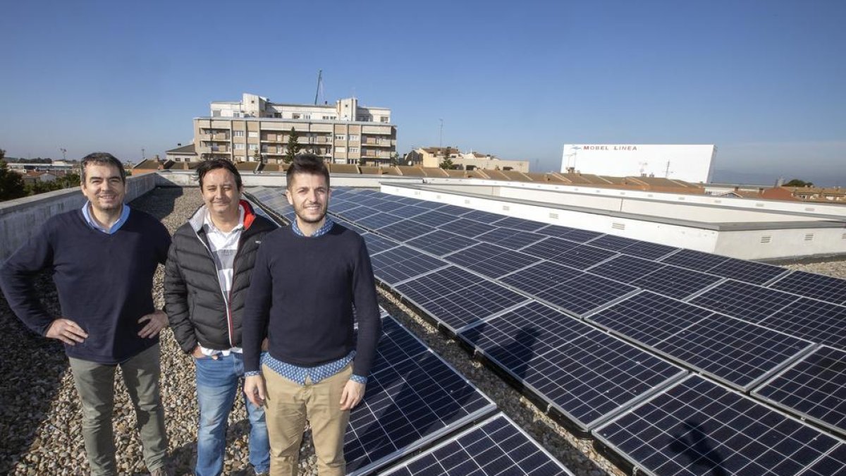 Oró (derecha) con dos profesores del instituto La Segarra y las placas fotovoltaicas que se han instalado.