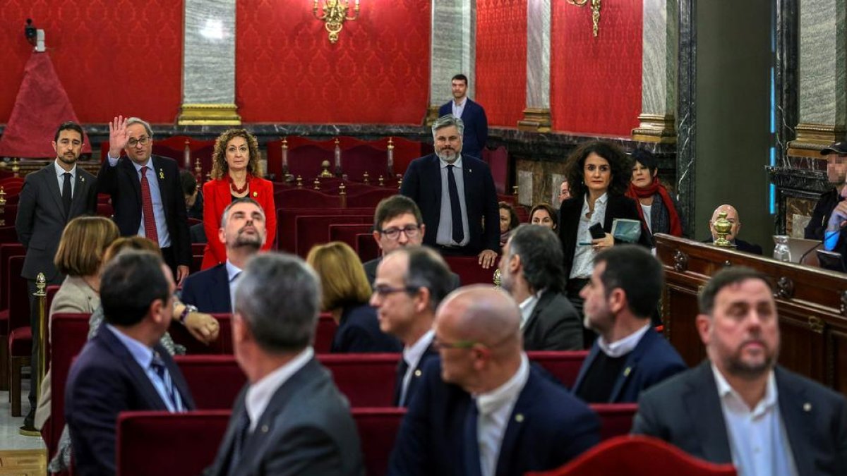 Els 12 líder independentistes, aquest dimarts a la banqueta dels acusats en la primera jornada del judici, amb el president Torra, al fons de la imatge, entre els assistents.