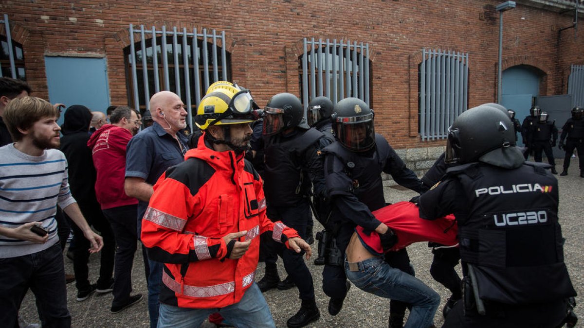 Policies nacionals carreguen en un col·legi electoral de Girona l’1-O en presència d’un bomber.