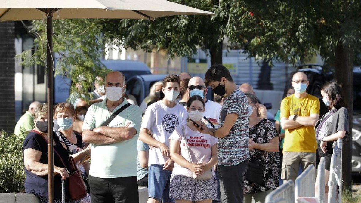 Ayer se formaron largas colas de personas a pleno sol en el barrio barcelonés de Torre Baró para participar en el cribado con pruebas PCR. 