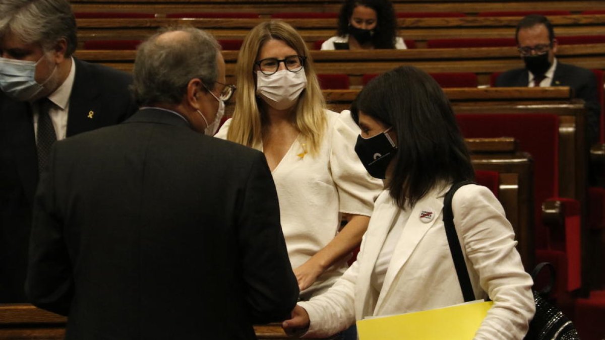 Marta Vilalta (ERC) saluda al presidente del Govern, Quim Torra, con Elsa Artadi (JxCat) en frente, en el hemiciclo.