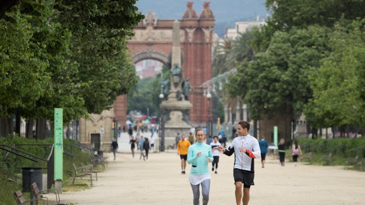 Decenas de personas paseando o practicando deporte en el parque de la Ciutat Vella de Barcelona.