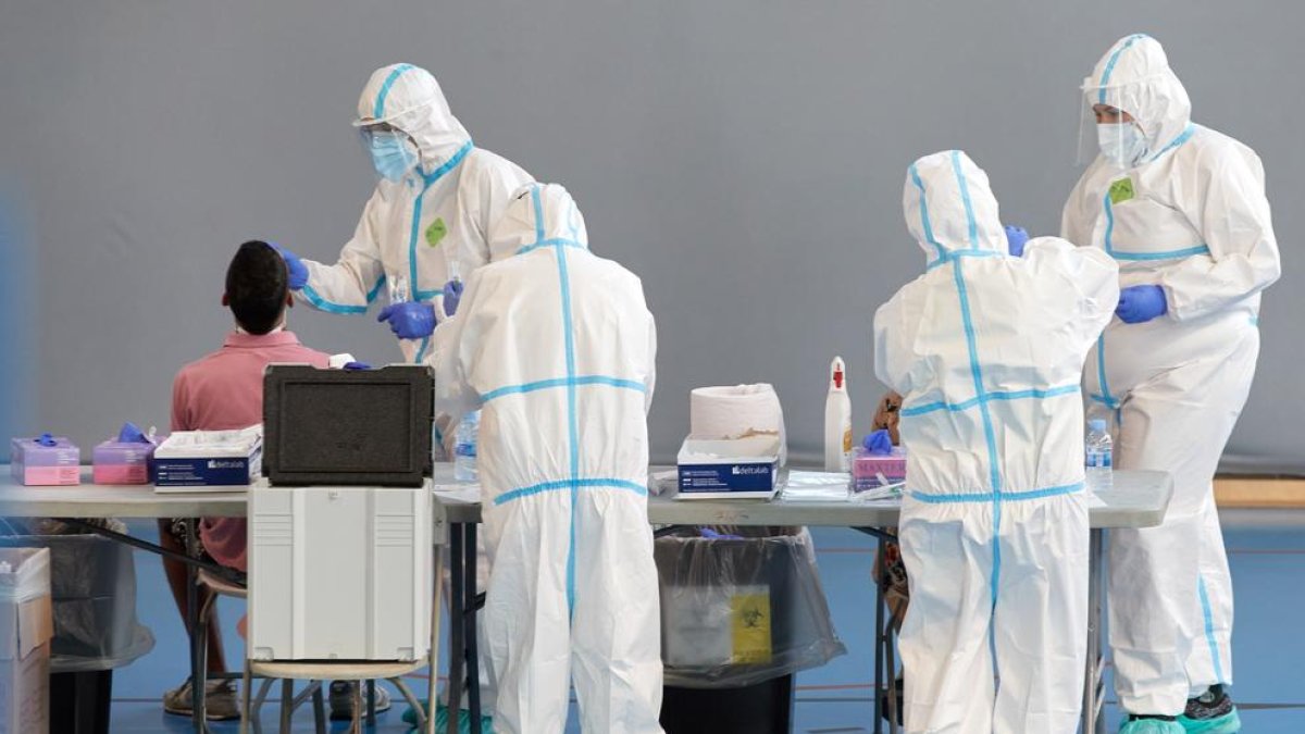 Tècnics sanitaris realitzen una prova de detecció del virus.