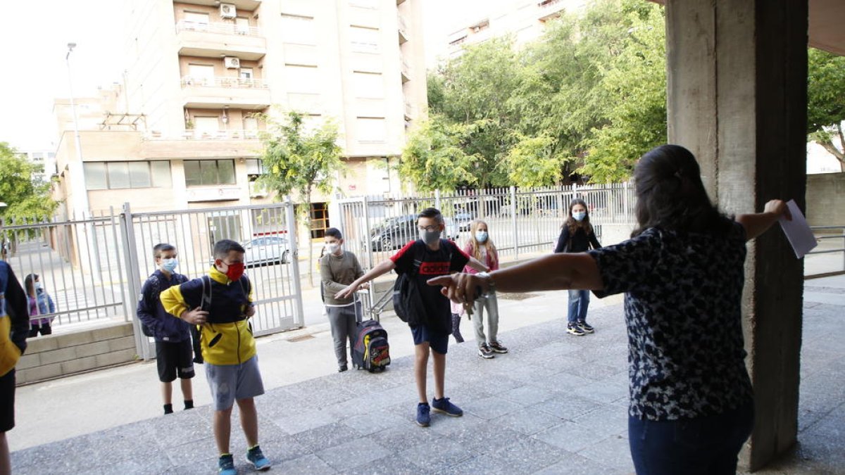 Alumnos con mascarilla  en la entrada de un colegio en junio.