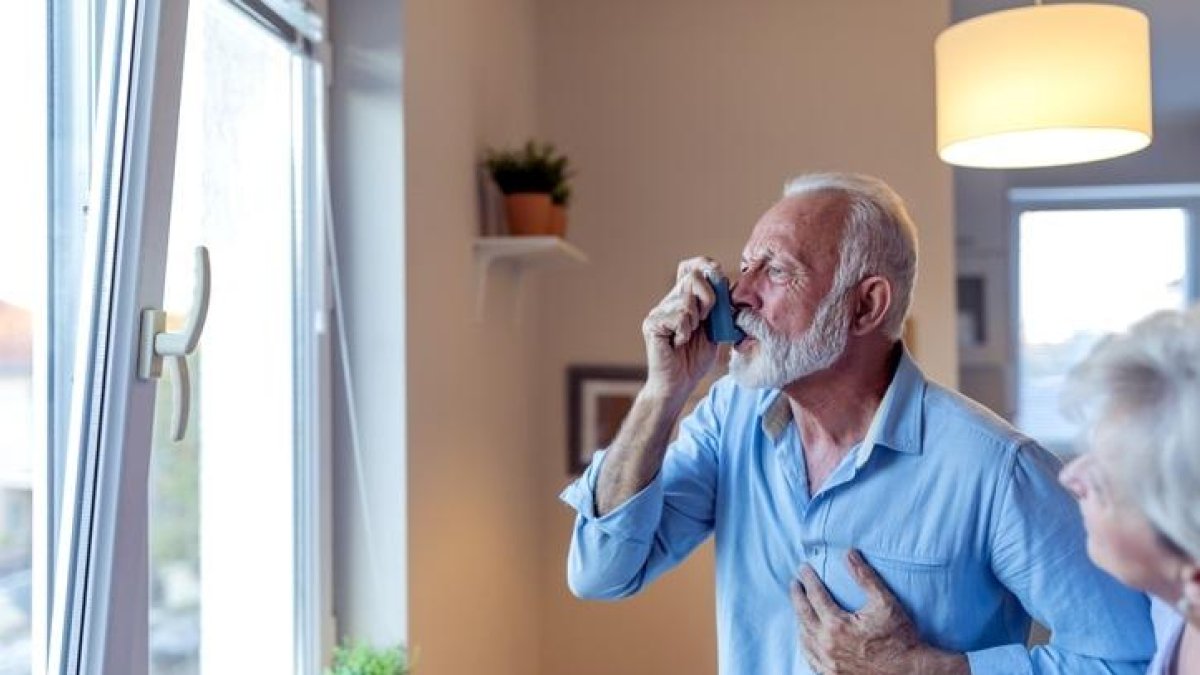 Un hombre asmático utiliza un inhalador.