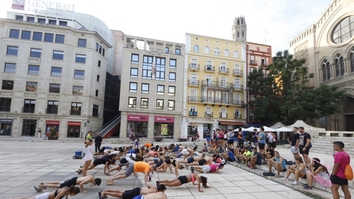 Alumnos bebiendo y haciendo flexiones como parte de las novatadas, ayer en la plaza Sant Joan.