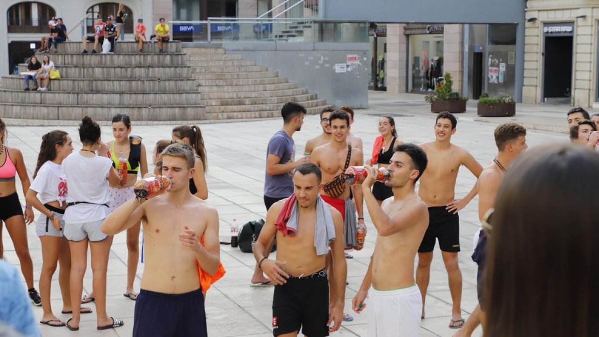 Alumnos bebiendo y haciendo flexiones como parte de las novatadas, ayer en la plaza Sant Joan.