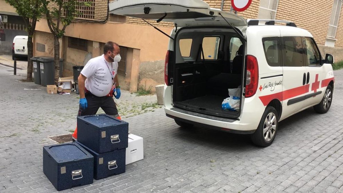 Un voluntario de Creu Roja Lleida repartiendo alimentos para los usuarios del comedor social Jericó, este verano.