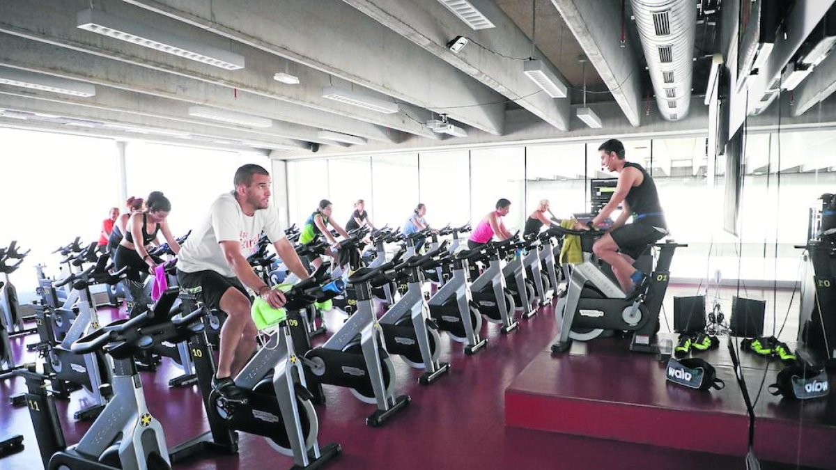 Un operario del gimnasio Trèvol desinfecta una máquina de fitness.