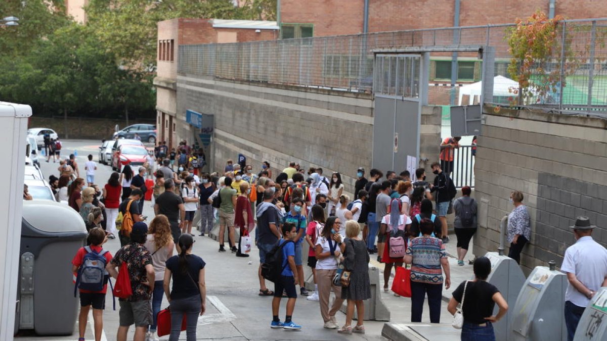 Imatge de grups de pares esperant davant les portes de dos col·legis de Lleida aquesta setmana. Ara, els centres no els permeten entrar als patis.
