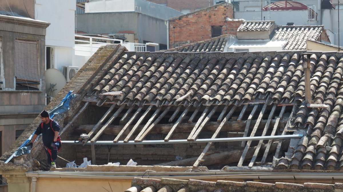 Un operari treballant ahir a la zona de la teulada de la capella que es va enfonsar al juliol per les pluges.