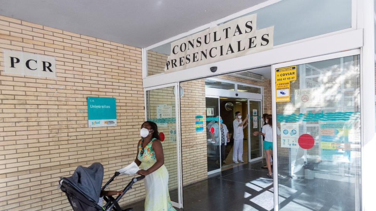 Una mujer sale con su bebé de un centro de salud de Zaragoza tras someterse a pruebas PCR.