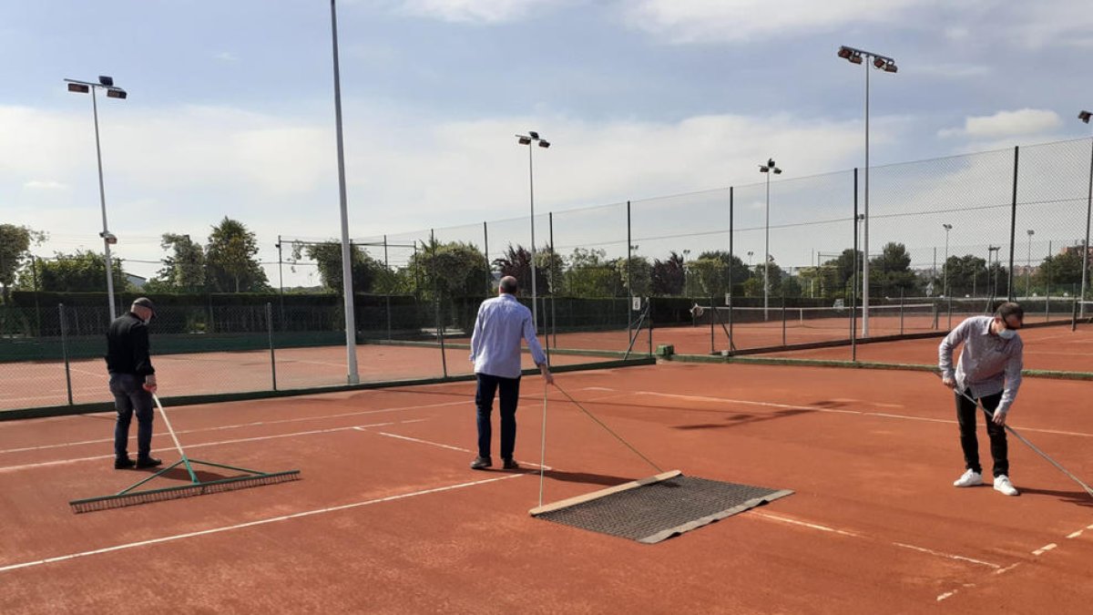 Un operari desinfecta l'entrada al recinte del Club Tennis Urgell, que també va posar a punt les pistes per a la reobertura avui de les instal·lacions