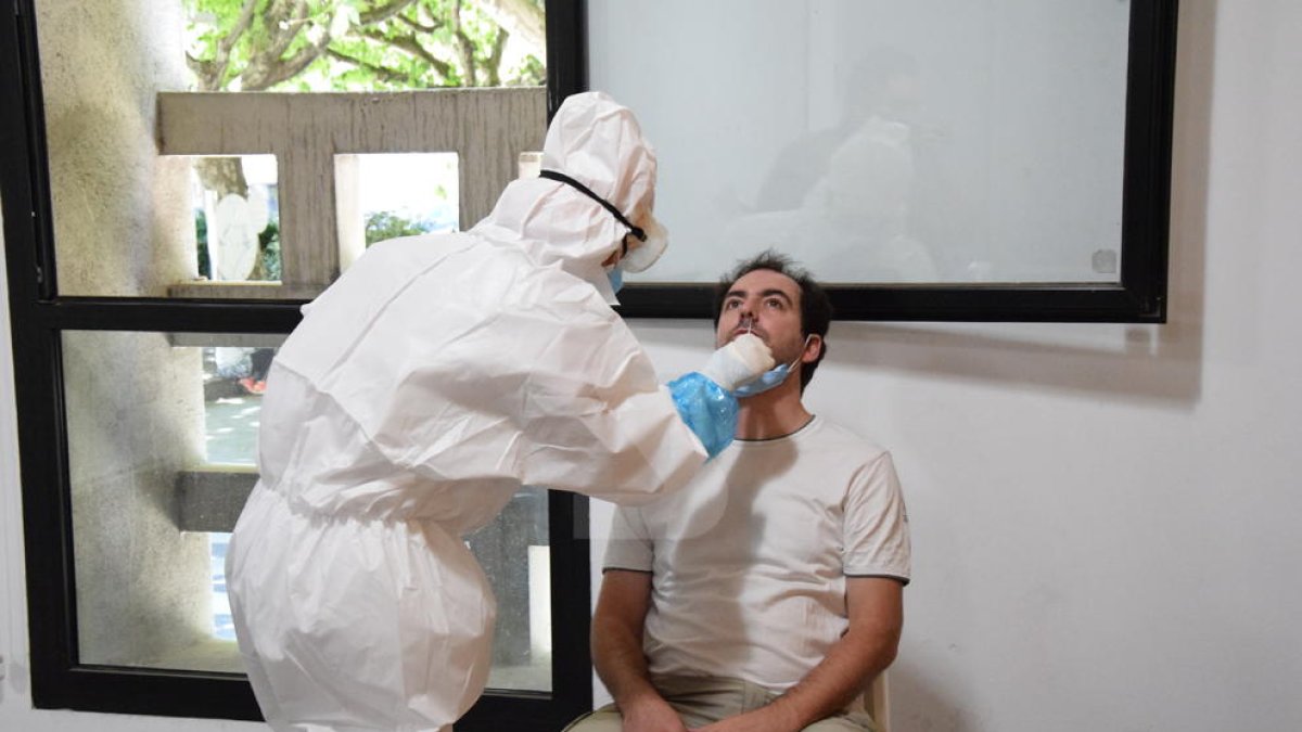 Un trabajador de un bar de la Seu sometiéndose ayer a la prueba de detección del coronavirus