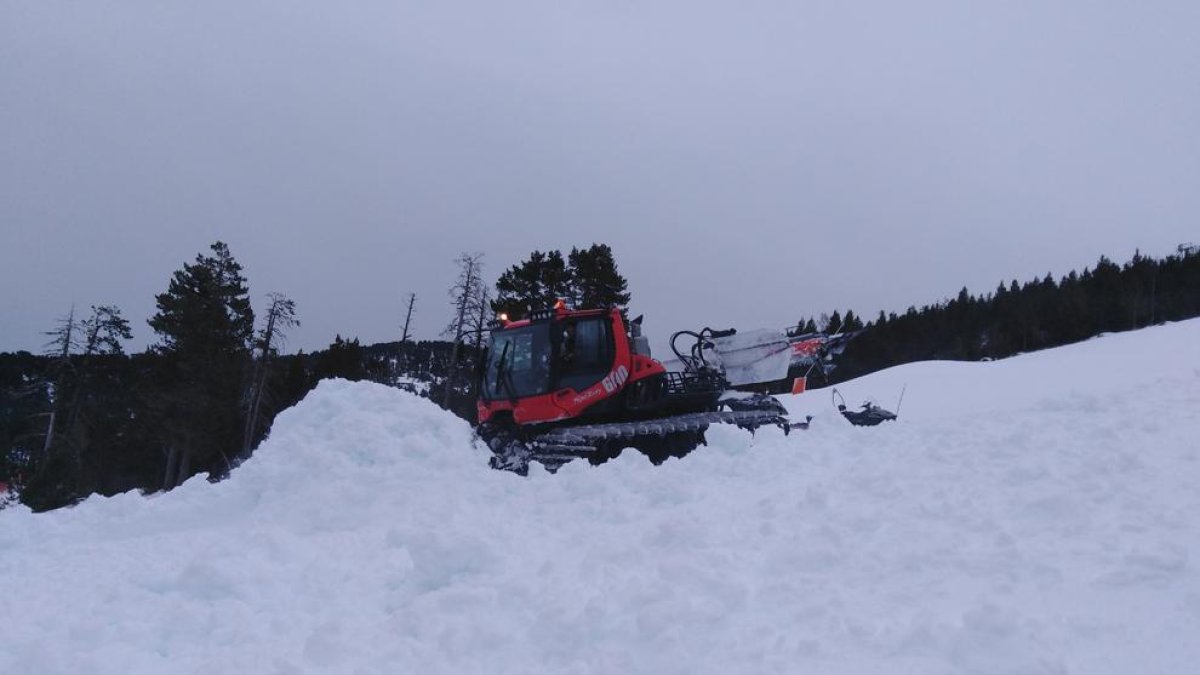 Esquiadores en Baqueira Beret que ofrece más de 100 kilómetros esquiables, mientras que las máquinas trabajan la nieve en Espot.