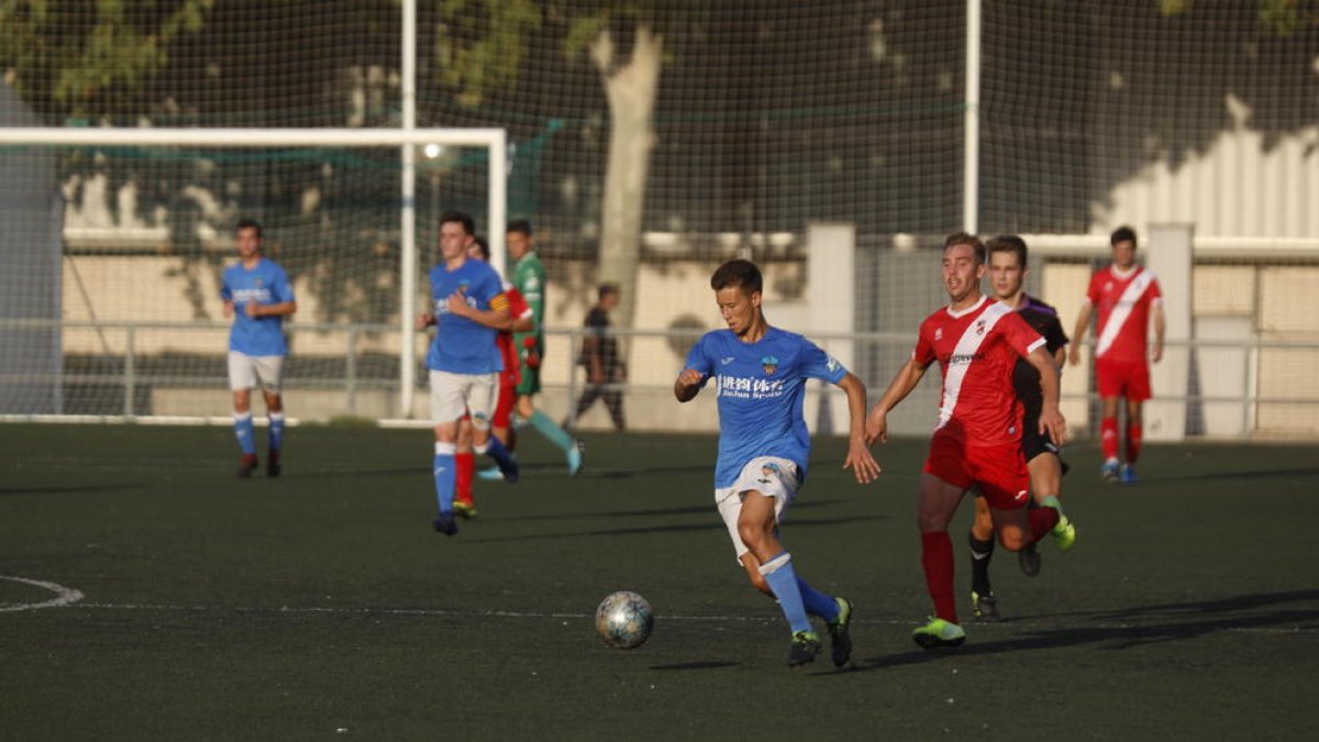 Un futbolista del Lleida controla el balón, seguido de otro del Artesa, ayer en Gardeny.
