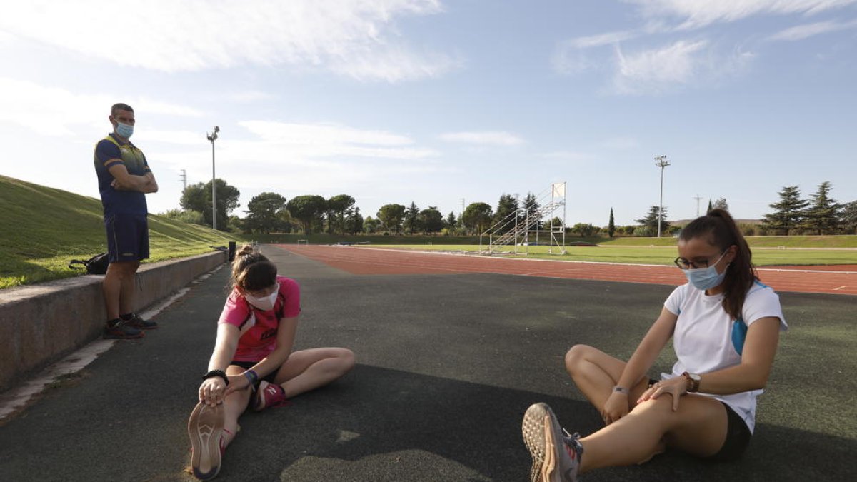 L’entrenador del Lleida UA, David Rubio, ahir a la pista de les Basses amb dos de les atletes que entrena.