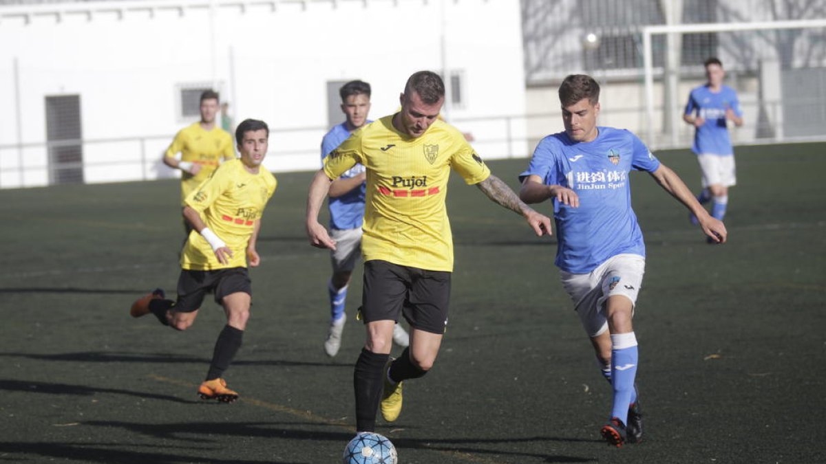 Un jugador del Mollerussa conduce el balón perseguido por otro del Lleida B, ayer durante el partido en Gardeny.