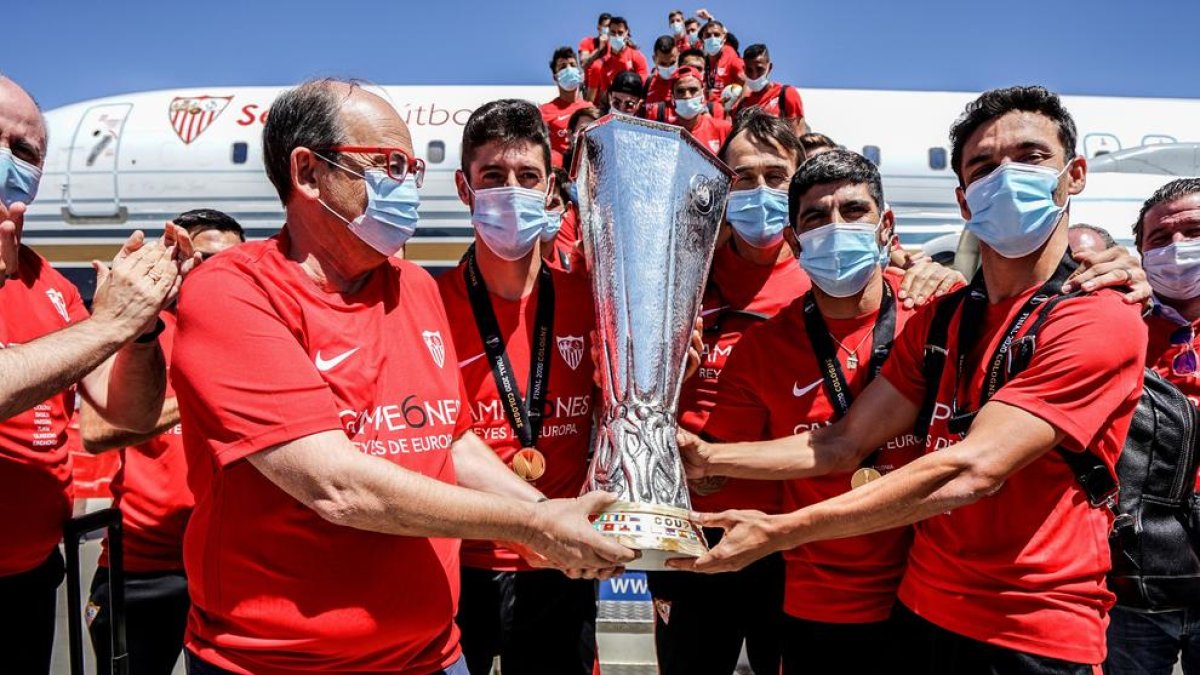 El president del Sevilla, Pepe Castro, i el capità, Jesús Navas, posen amb el trofeu al baixar de l’avió.