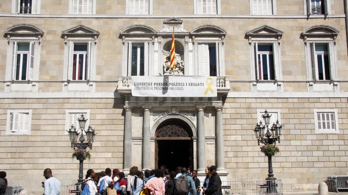 Passat el període electoral, el president, Quim Torra, va tornar a posar ahir la pancarta pels presos i exiliats al Palau de la Generalitat.