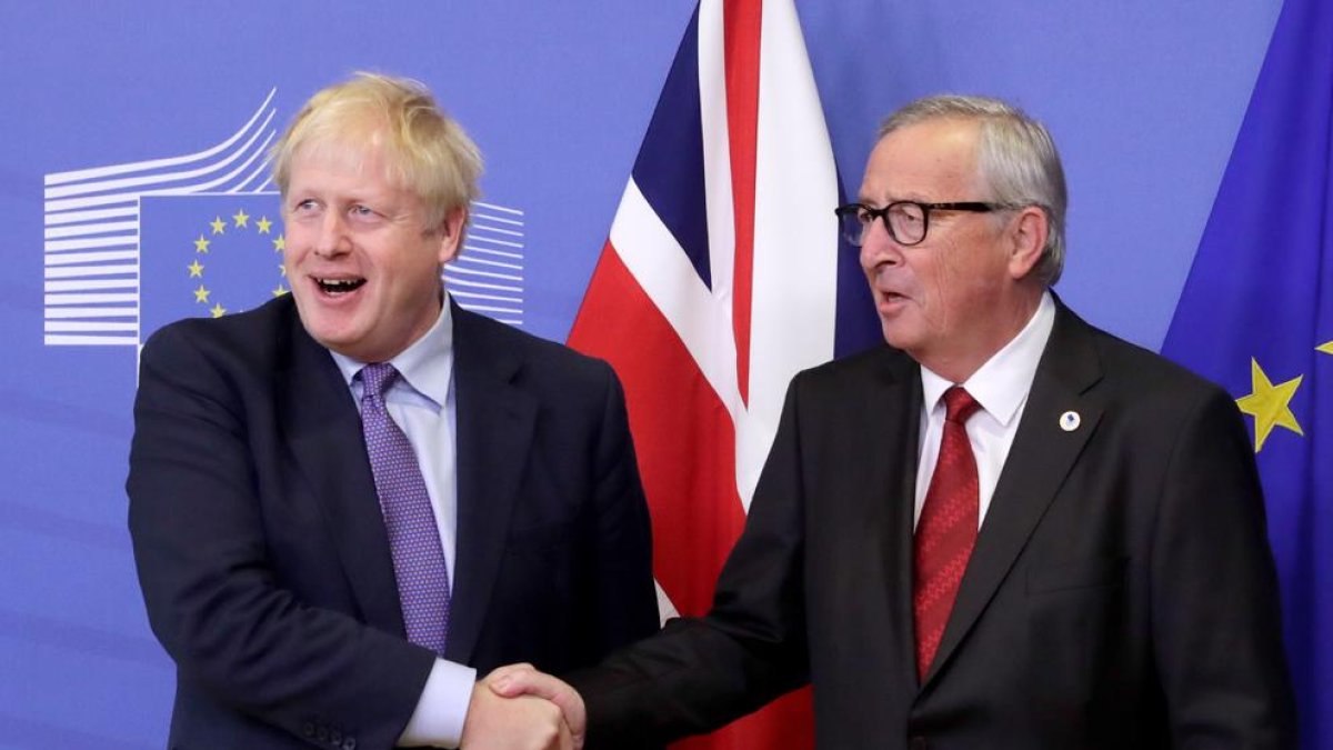 Boris Johnson y Jean-Claude Juncker se dan la mano en la apertura del Consejo Europeo, que se celebró ayer.