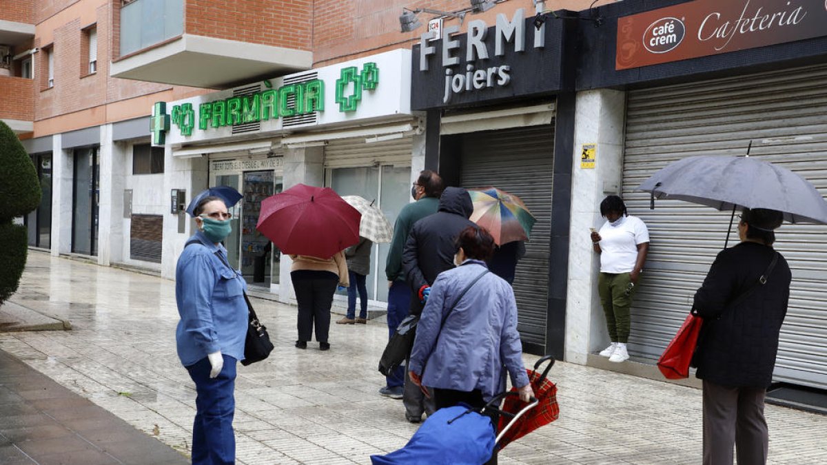 Ciudadanos haciendo cola ante una farmacia de Lleida en una imagen de archivo.