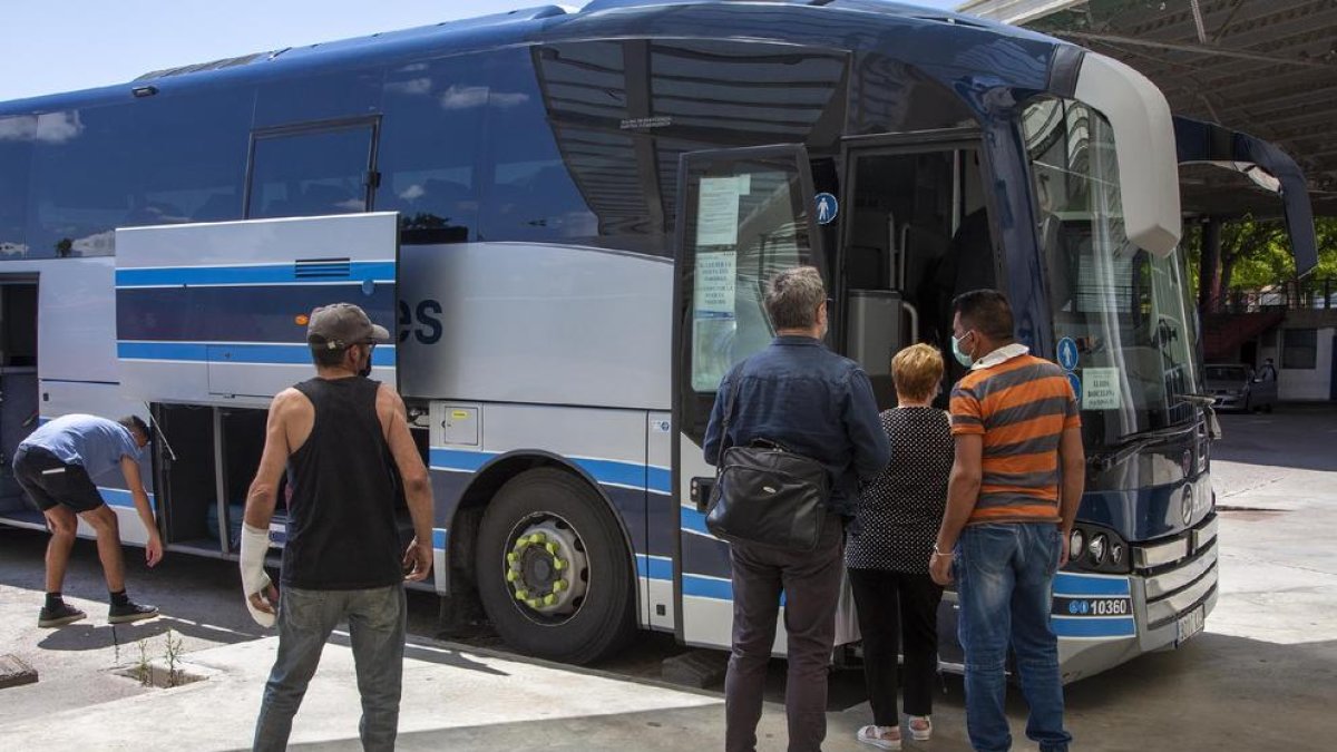 Pasajeros subiendo ayer en Tàrrega a un autocar hacia Barcelona.