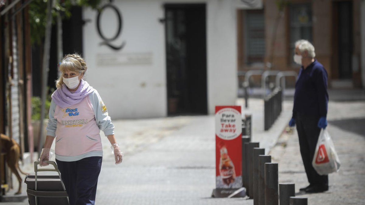 Una dona amb mascareta i guants, ahir, en un carrer de Sevilla.