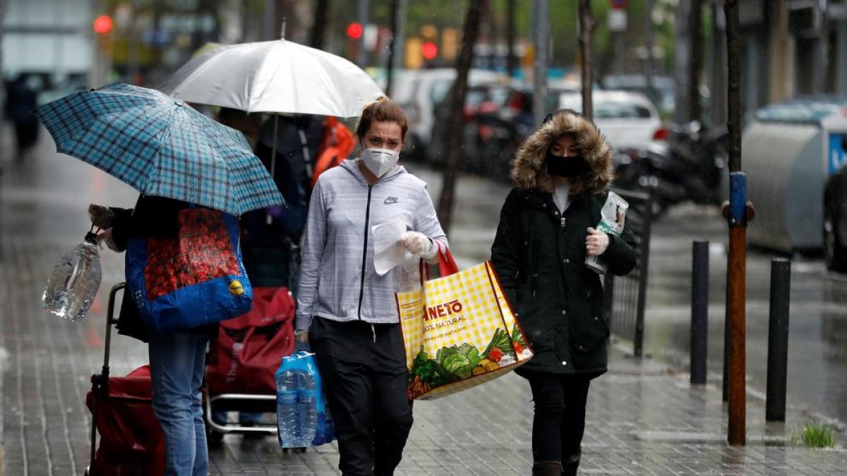 Diverses persones ahir a l’Hospitalet, trenta-vuitè dia de l’estat d’alarma, després d’anar a comprar.