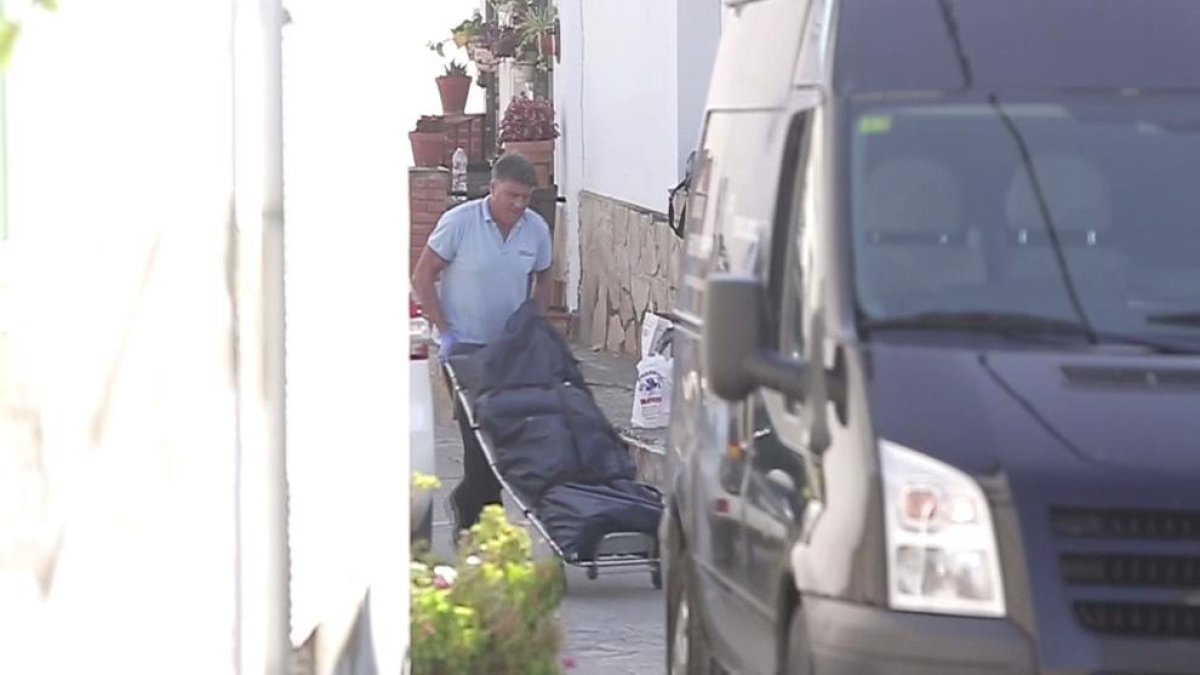 Los servicios funerarios llevándose el cuerpo de la mujer asesinada en Málaga.