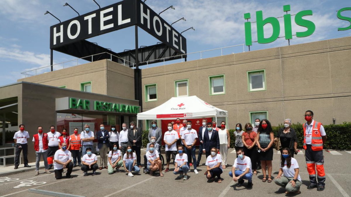 L’equip de treballadors de la Creu Roja, amb diverses autoritats, ahir a l’exterior de l’Hotel Ibis.