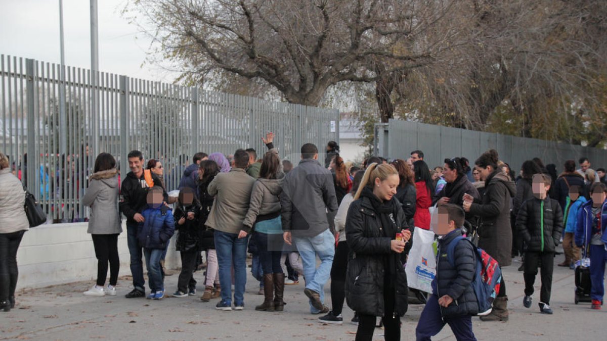 Pares i mares i alumnes a la sortida d'una escola.-