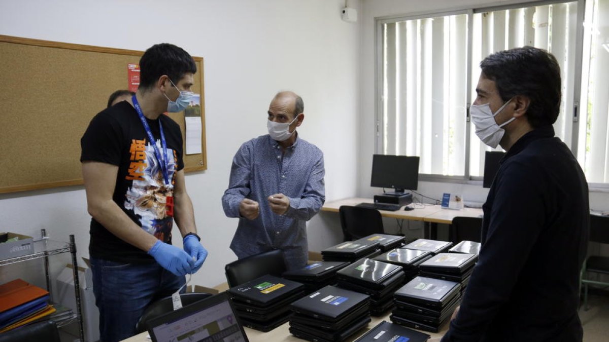 Responsables de l'institut Josep Lladonosa i tècnics preparen els ordinadors.