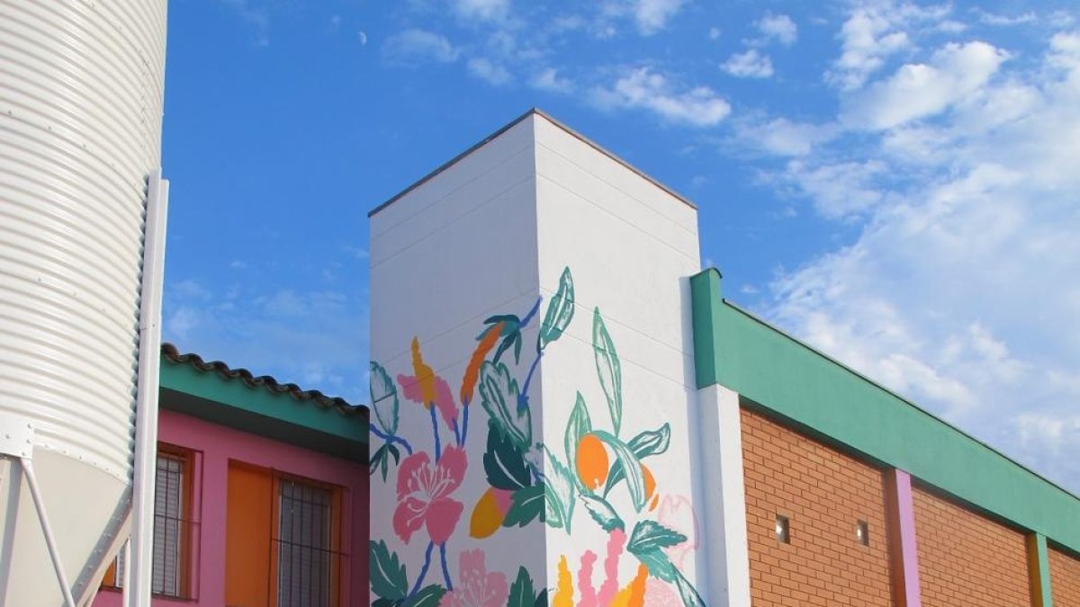 L’artista Lara Costafreda pintant l’exterior de l’escola.