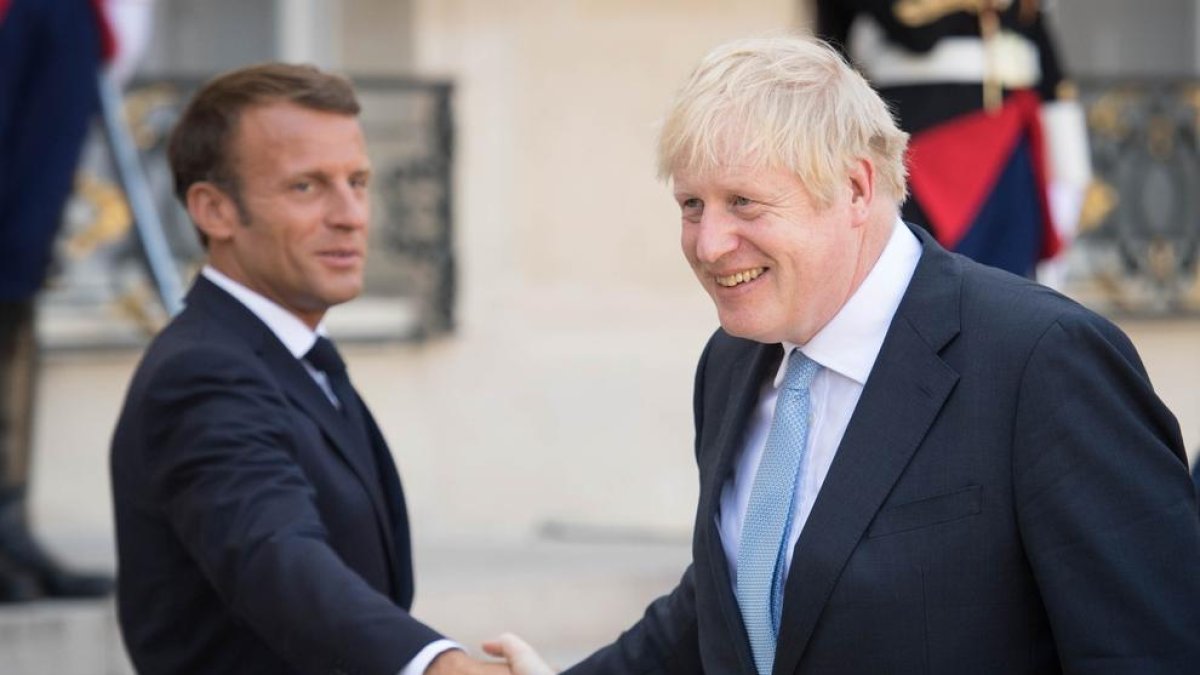 Macron i Johnson es donen la mà després de la reunió.