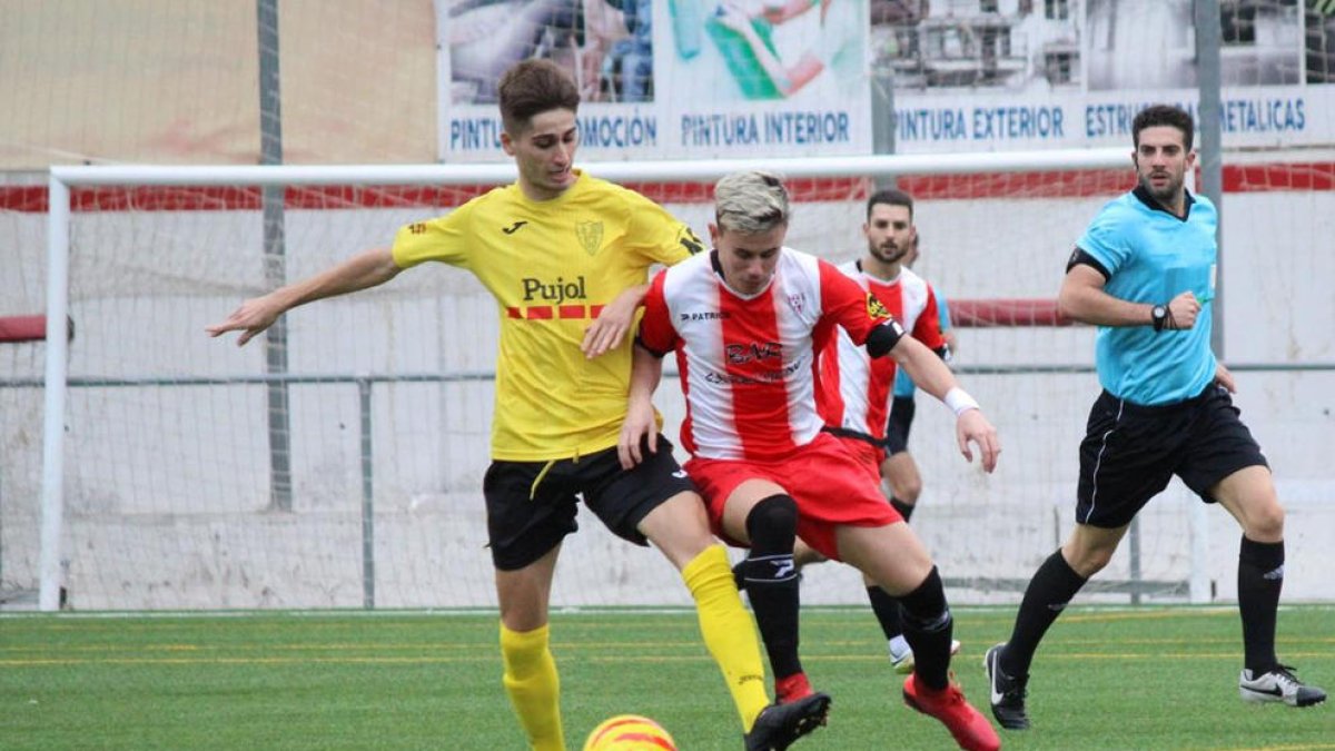 Un jugador del Mollerussa defiende el balón ante un rival en una acción del partido.