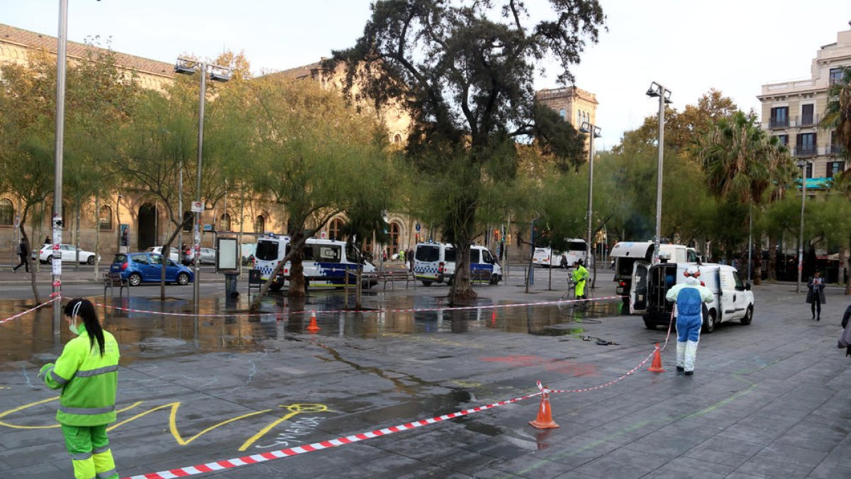 Operarios limpian la zona de la acampada, ayer, en Barcelona.